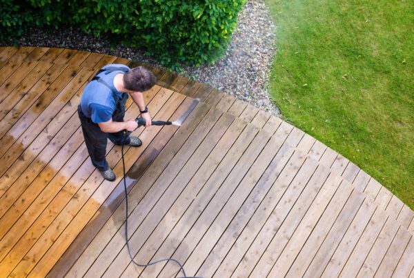 Man cleaning decking with a pressure washer